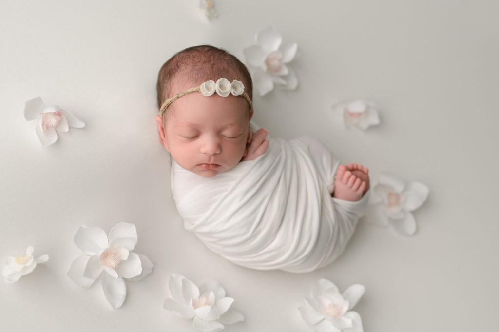 Spring newborn photos with loose white flowers