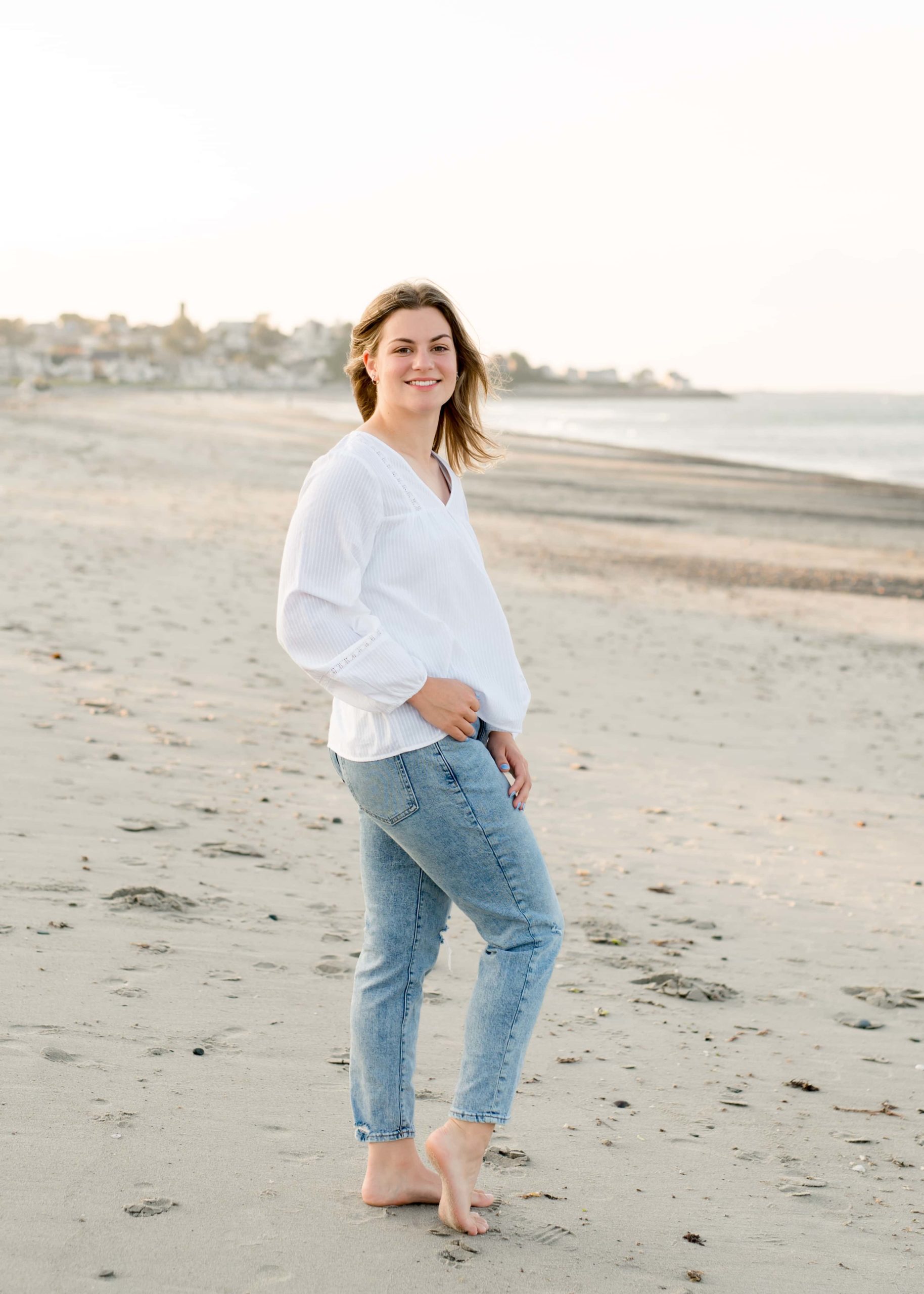 Senior pictures at Nantasket Beach with a white shirt and blue jeans