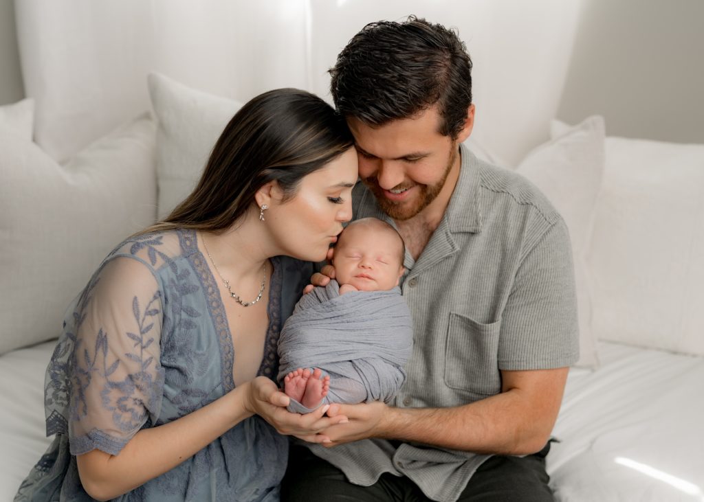 Boston newborn photography with parents holding swaddled baby